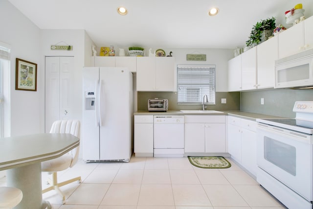 kitchen with white cabinetry, light tile patterned floors, white appliances, and sink