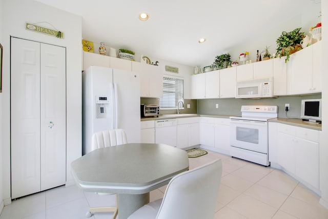 kitchen with white appliances, light tile patterned floors, and white cabinetry