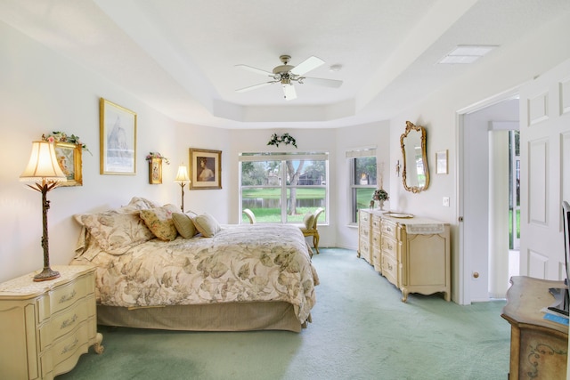 bedroom featuring a tray ceiling, ceiling fan, and light colored carpet