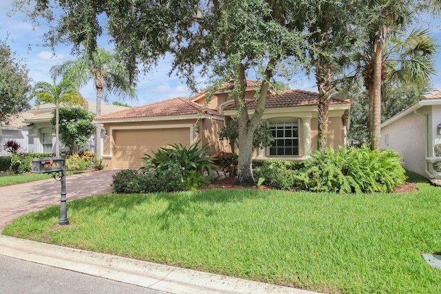 mediterranean / spanish-style house with a garage and a front lawn