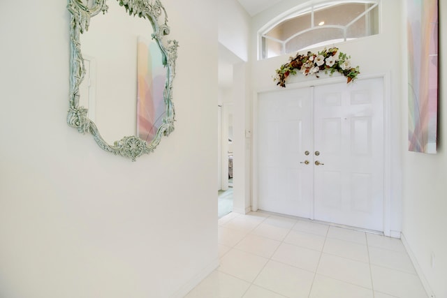 tiled entryway featuring a towering ceiling