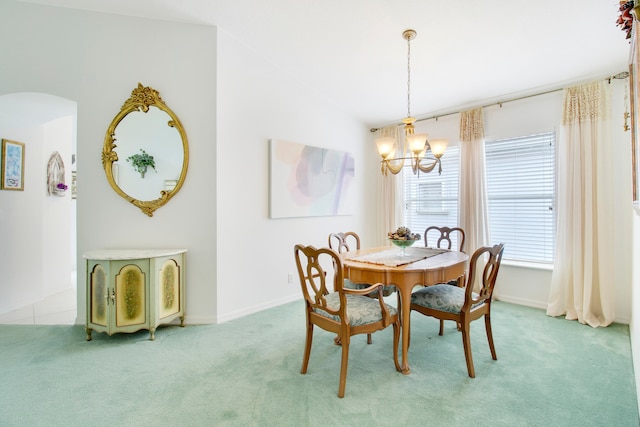 carpeted dining area featuring lofted ceiling and a notable chandelier