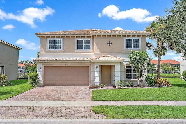 mediterranean / spanish home featuring a garage and a front yard