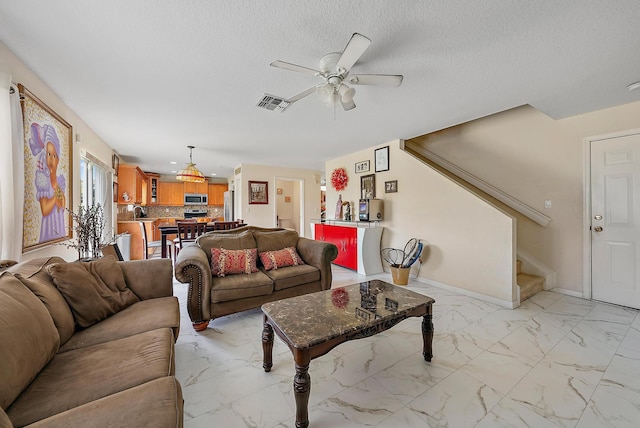 tiled living room with a textured ceiling and ceiling fan