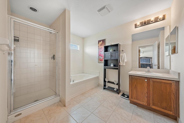 bathroom featuring a textured ceiling, vanity, tile patterned floors, and plus walk in shower