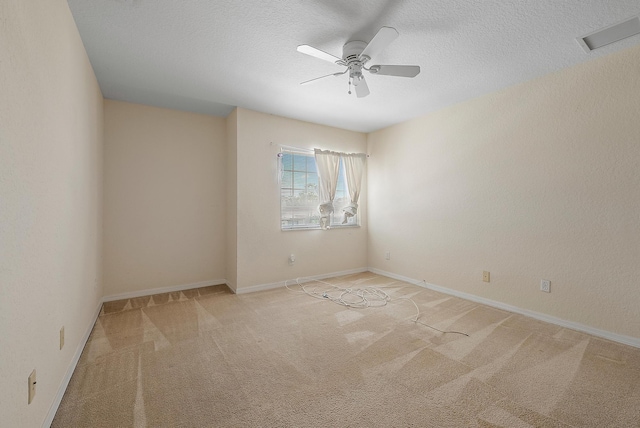 spare room featuring light carpet, a textured ceiling, and ceiling fan