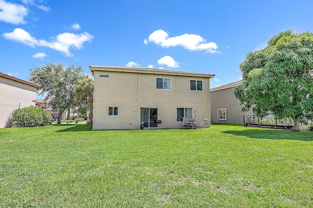 rear view of property featuring a yard