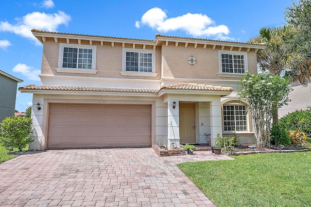 mediterranean / spanish home featuring a garage and a front yard