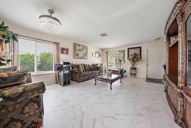 living room with a textured ceiling and light tile patterned floors