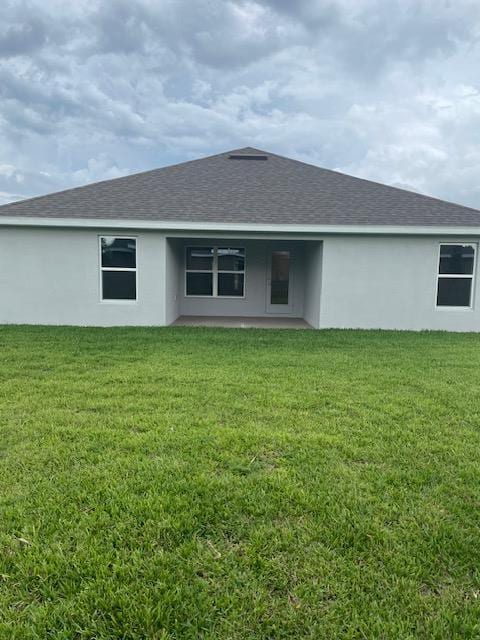 rear view of property with a lawn