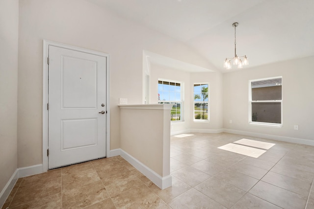 tiled entryway with a notable chandelier and lofted ceiling