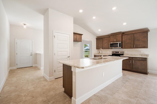 kitchen with appliances with stainless steel finishes, dark brown cabinetry, sink, lofted ceiling, and an island with sink