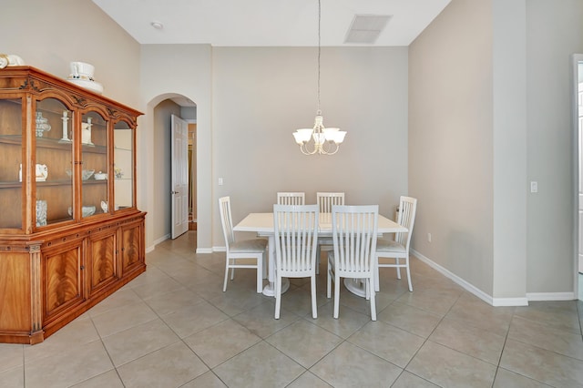 dining room featuring vaulted ceiling, light tile patterned floors, and an inviting chandelier