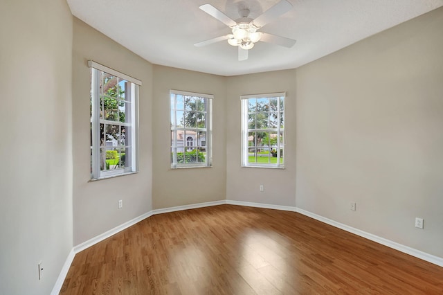 spare room featuring hardwood / wood-style flooring, ceiling fan, and a healthy amount of sunlight