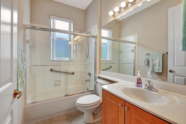 full bathroom with shower / bath combination with glass door, vanity, tile patterned floors, and toilet