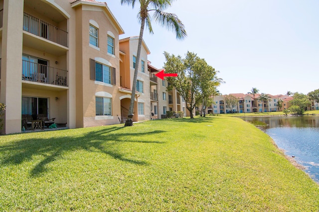 view of property's community with a yard and a water view