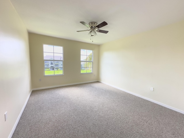 empty room featuring ceiling fan and carpet