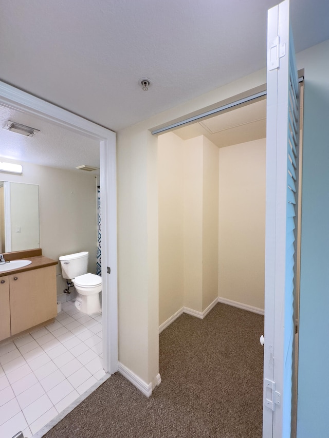 interior space with vanity, toilet, and tile patterned floors