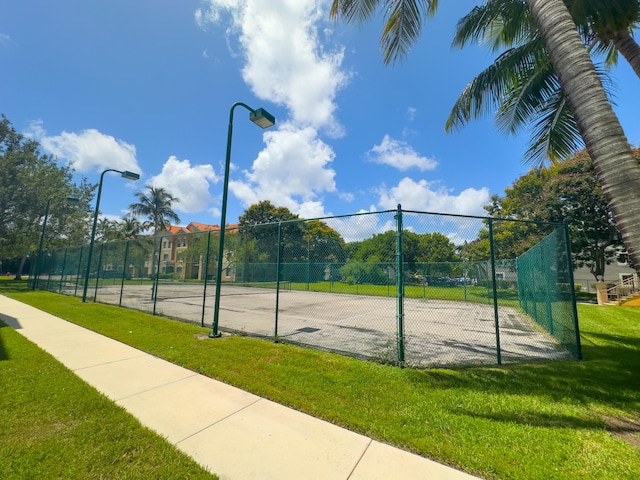 view of sport court with a yard