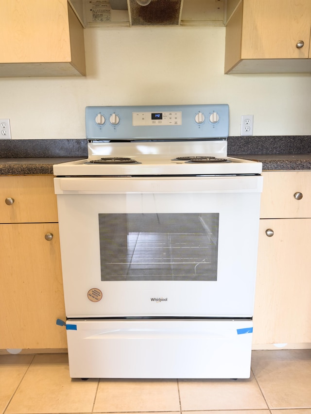 room details with white electric range, light brown cabinetry, and light tile patterned floors