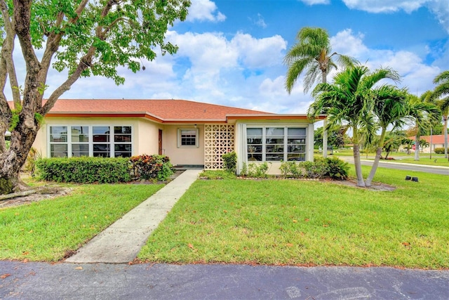 ranch-style home featuring a front lawn