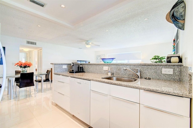 kitchen with white cabinetry, white dishwasher, visible vents, and a sink