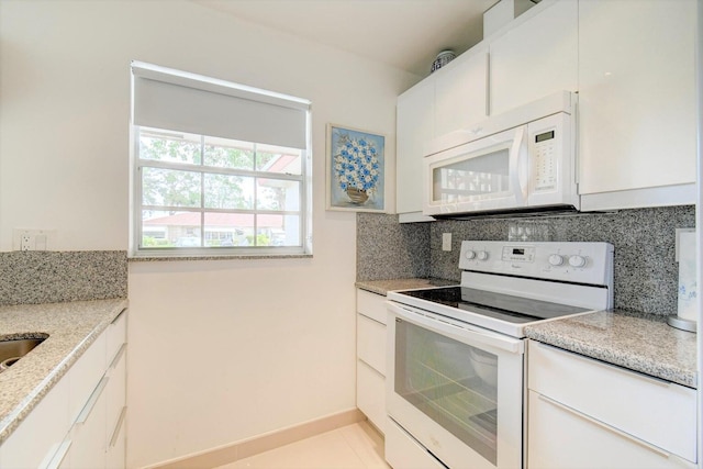 kitchen with white appliances, white cabinetry, backsplash, and light stone countertops