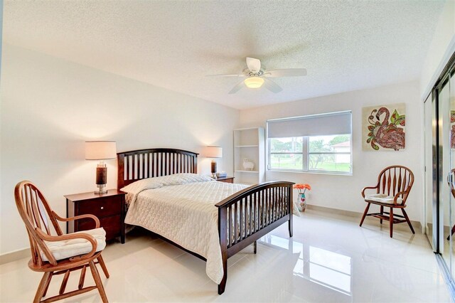 bedroom featuring a textured ceiling, ceiling fan, light tile patterned flooring, and a closet