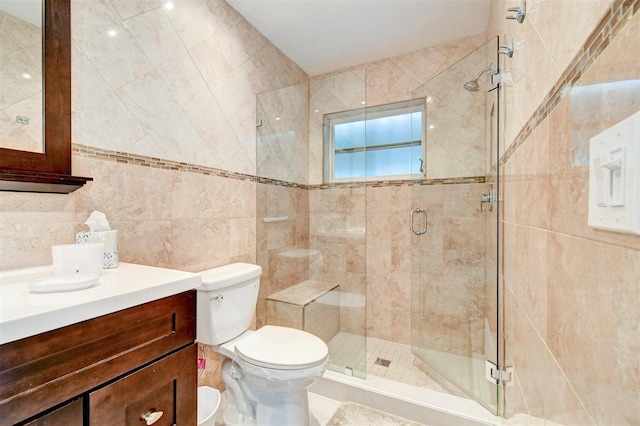 bathroom featuring toilet, a stall shower, tile walls, and vanity