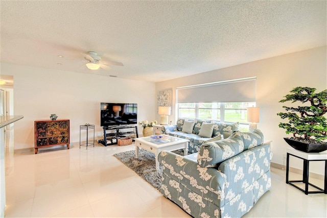 living area with a ceiling fan and a textured ceiling