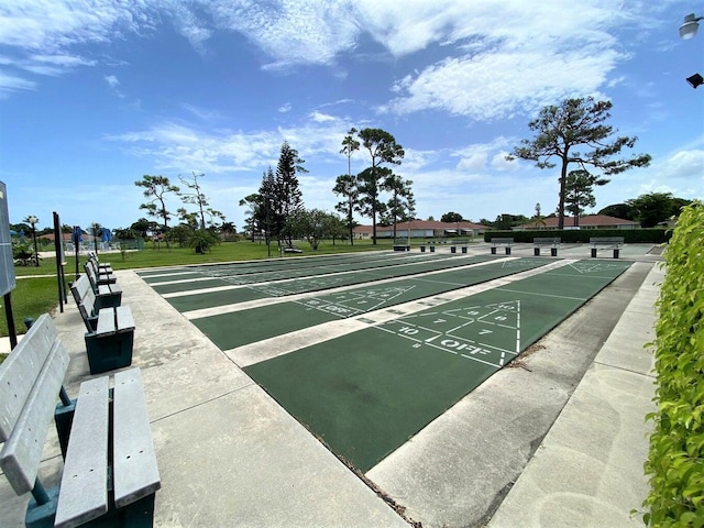 view of community with shuffleboard and a lawn