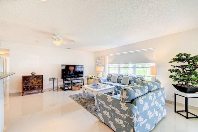 living room with tile patterned flooring, ceiling fan, and a textured ceiling