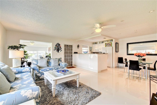 living area featuring a textured ceiling and a ceiling fan