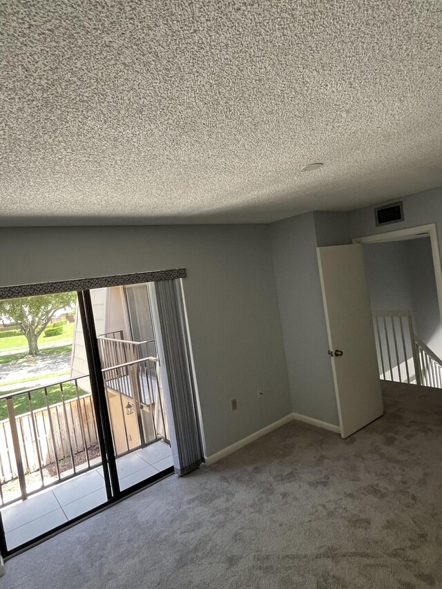 carpeted spare room featuring a textured ceiling