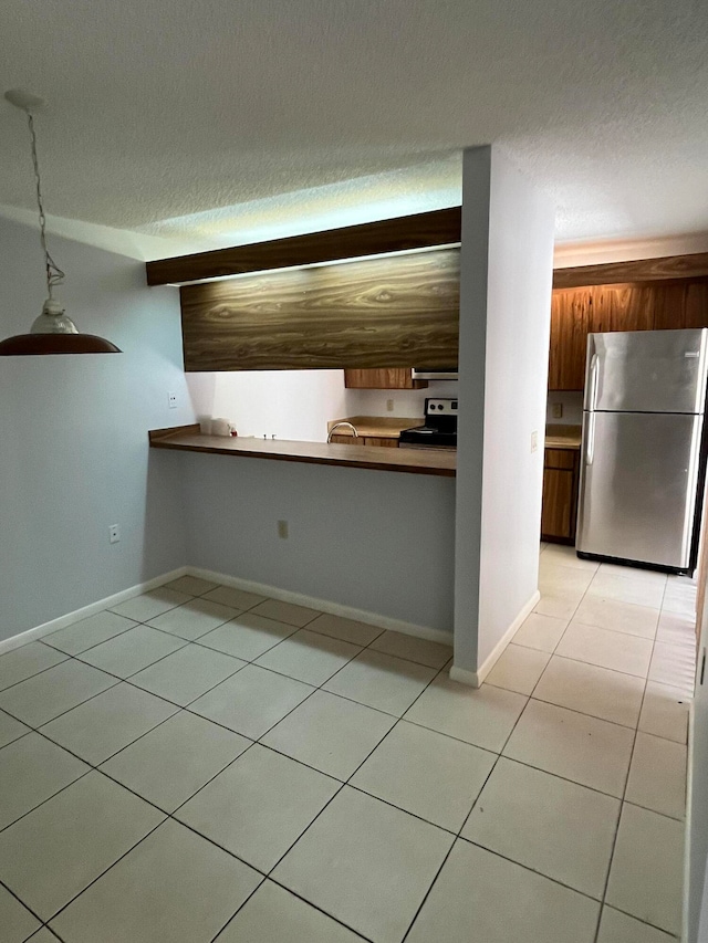 kitchen featuring pendant lighting, a textured ceiling, light tile patterned floors, sink, and appliances with stainless steel finishes