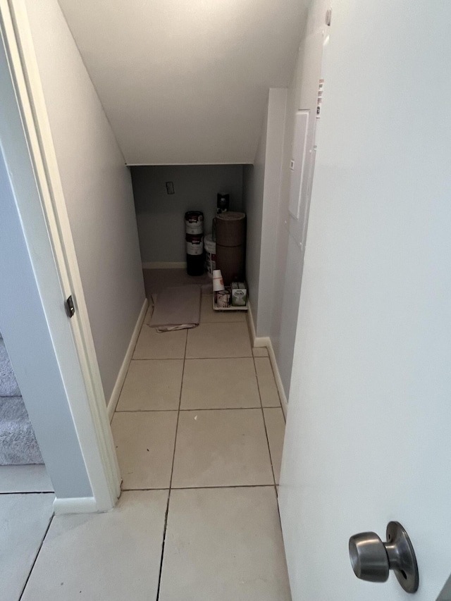 hall with baseboards and tile patterned floors