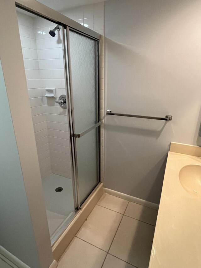 bathroom featuring vanity, tile patterned flooring, and a shower with door