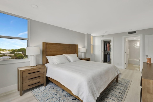 1801 S Flagler Dr Unit 701, West Palm Beach, FL 33401 - bedroom with ensuite bathroom, visible vents, baseboards, a spacious closet, and light wood-type flooring