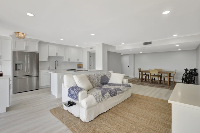 living room featuring light hardwood / wood-style floors and sink