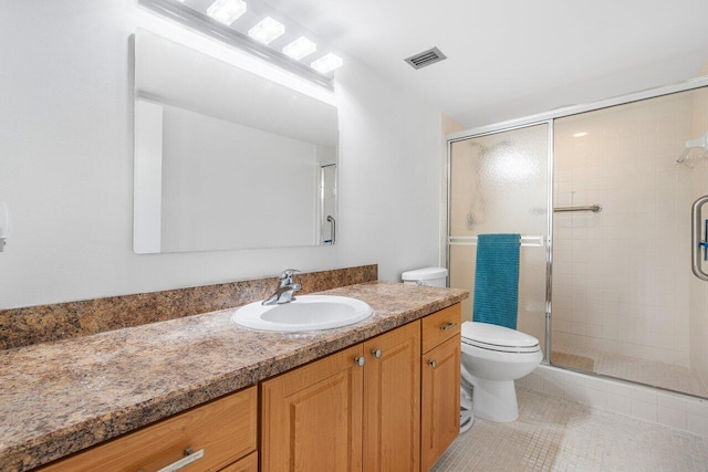 bathroom with vanity, toilet, walk in shower, and tile patterned floors