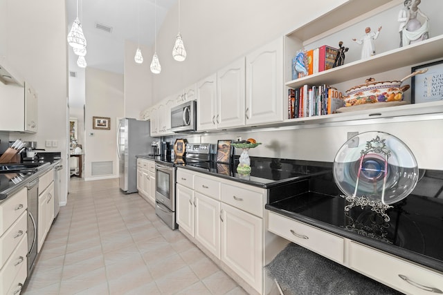 kitchen with white cabinets, stainless steel appliances, hanging light fixtures, and light tile patterned floors