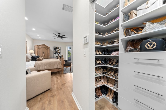 spacious closet with ceiling fan and light hardwood / wood-style flooring