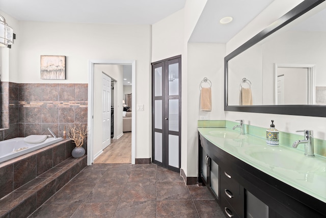 bathroom with vanity, tiled bath, and tile walls