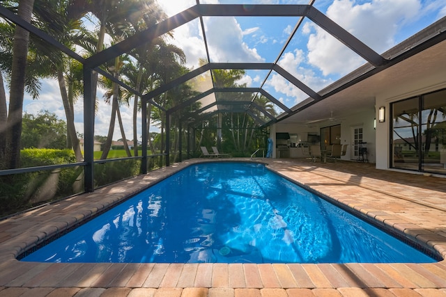 view of pool with a lanai, a patio, and ceiling fan