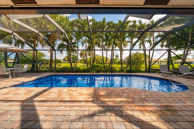 view of pool featuring glass enclosure and a patio area