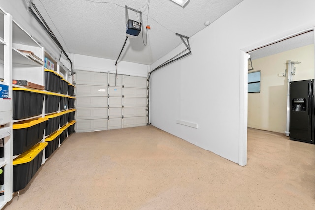 garage featuring a garage door opener and black fridge