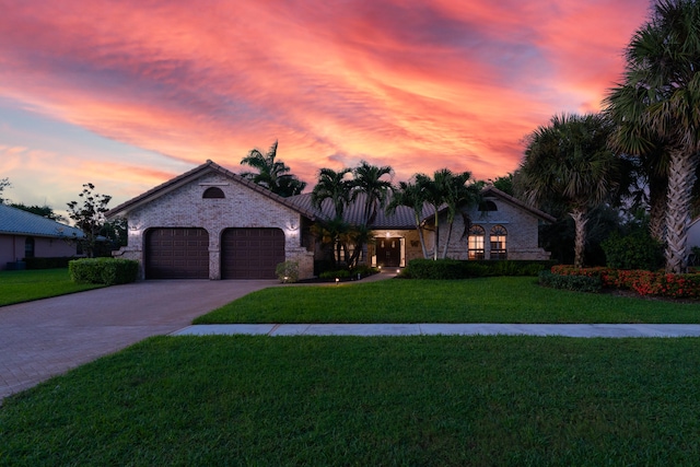 view of front of home featuring a garage and a yard