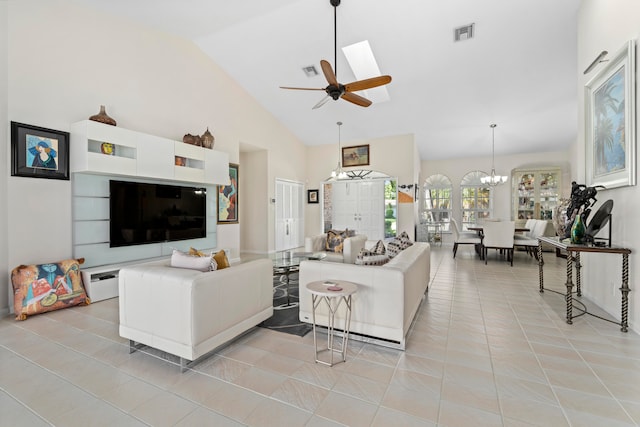 living room with ceiling fan with notable chandelier, light tile patterned flooring, and high vaulted ceiling