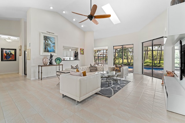 living room featuring high vaulted ceiling, ceiling fan, a skylight, and light tile patterned floors