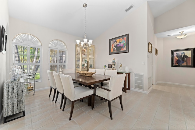 dining space featuring lofted ceiling, a chandelier, and light tile patterned floors